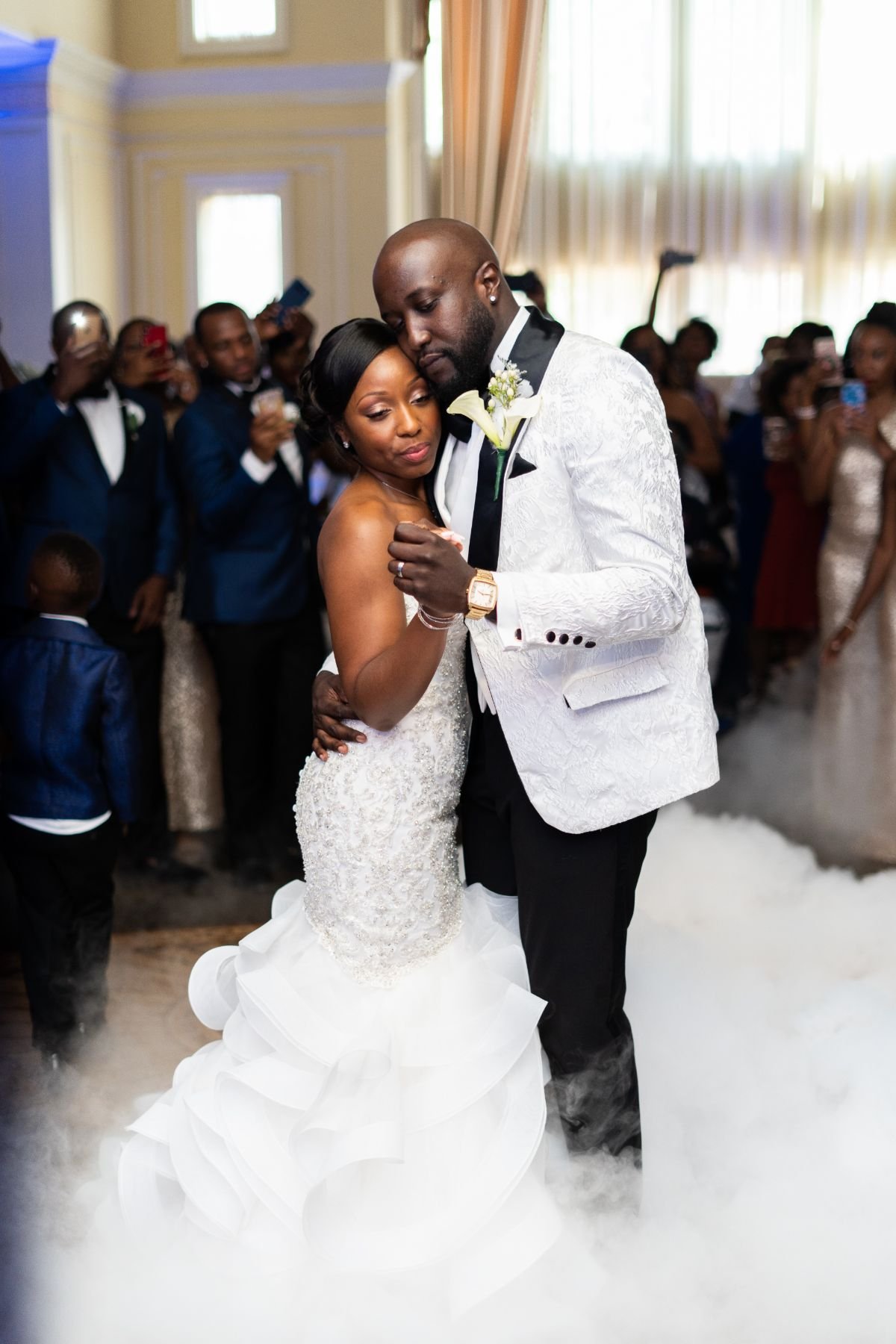 A bride and groom holding each other and dancing