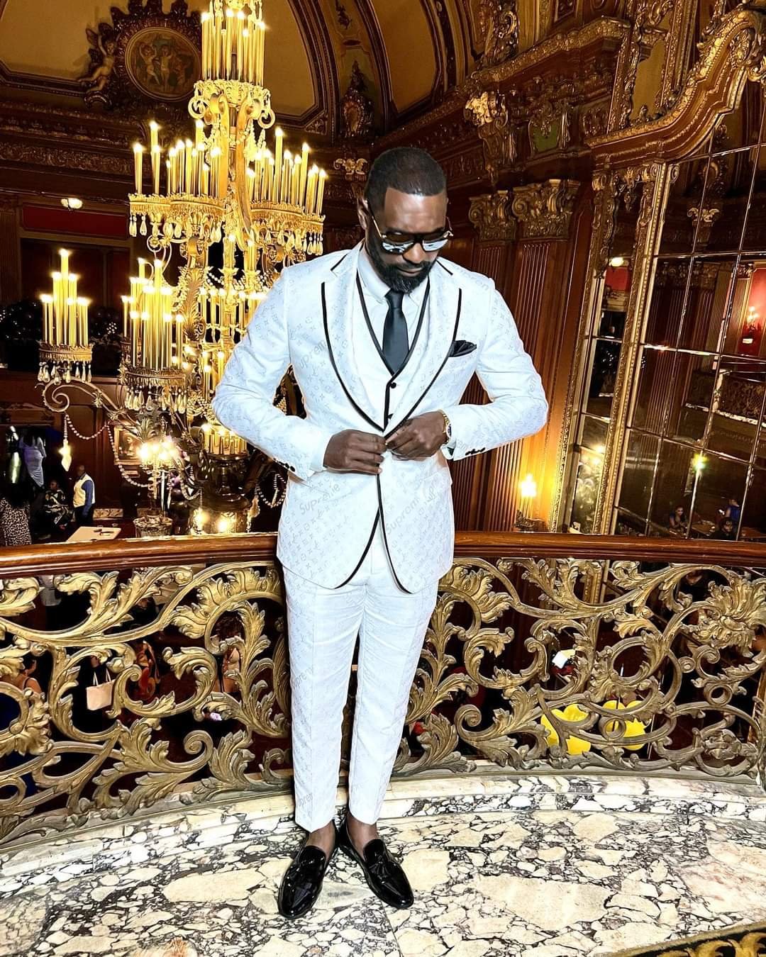 A man standing in a cathedral wearing a black and white custom Suit