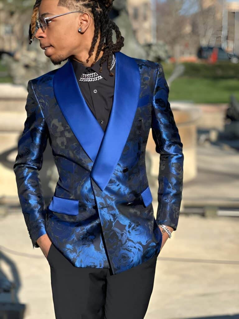 A teenager in a custom blue and black suit standing outside