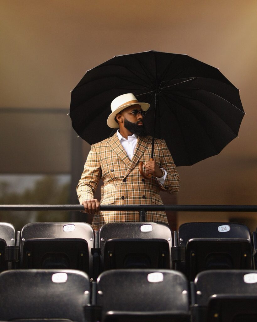 Kosi Ross in a plaid orange and green suit at a racetrack