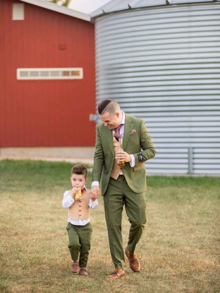 A father and child walking and holding hands. Custom Suits Kansas City