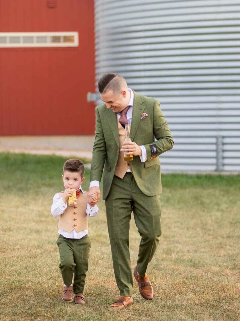 A father and child walking and holding hands. Custom Suits Kansas City