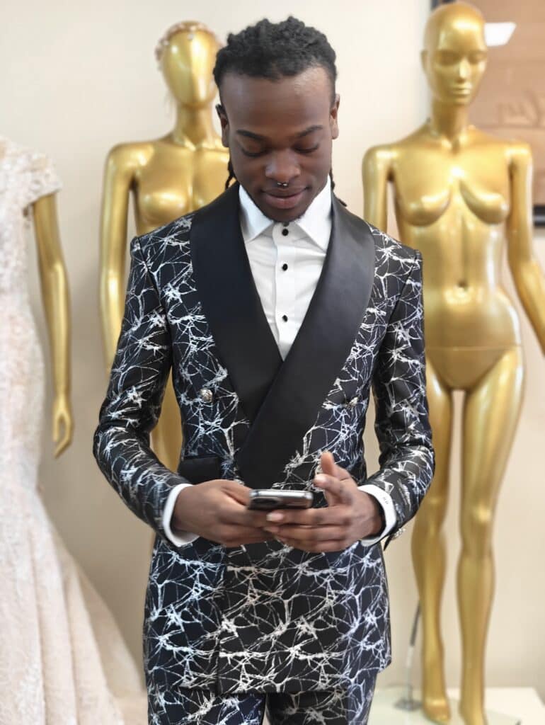 a teen standing in a black and Silver foil print tuxedo